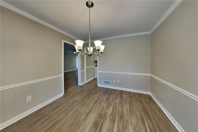 a view of a room with wooden floor staircase and a kitchen