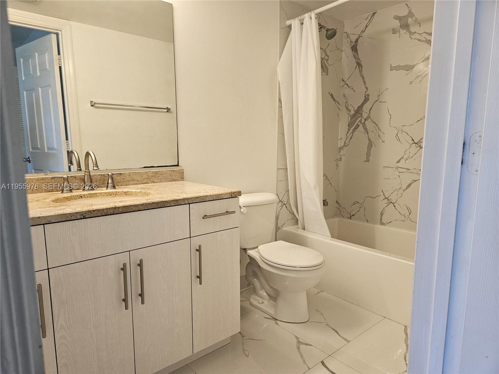 5011 Wiles Road, Unit 306 Coconut Creek, FL 33073 - Photo 8 of 17 a bathroom with a sink toilet and shower