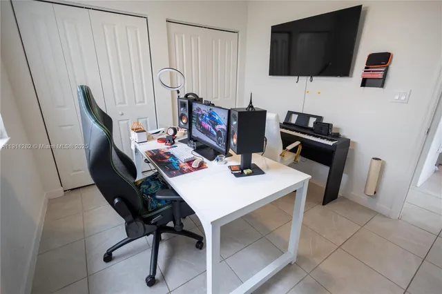 a view of a workspace with furniture and a flat screen tv