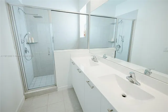 a bathroom with a sink a shower and a mirror