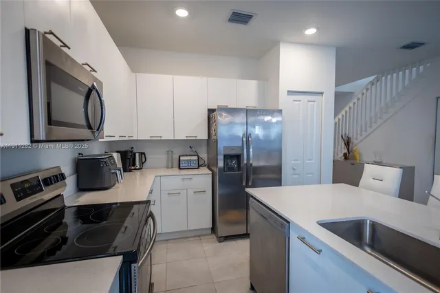 a kitchen with a refrigerator and a stove top oven