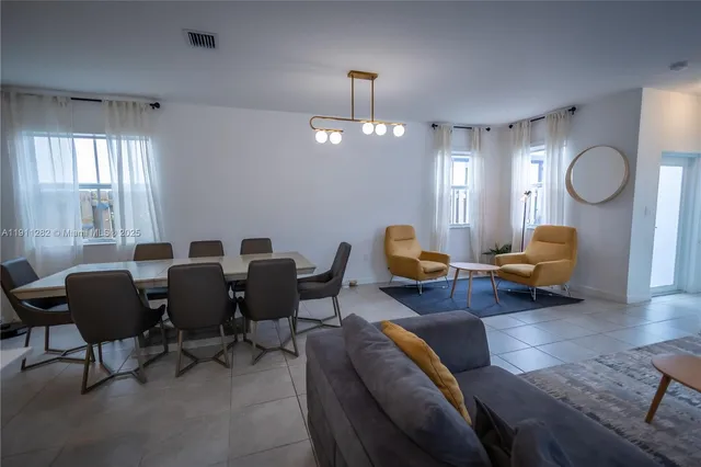 a living room with furniture chandelier and a window