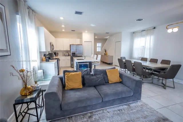 a living room with furniture and kitchen view