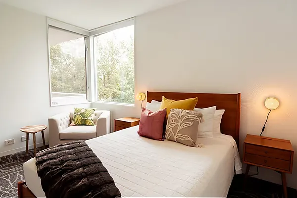 a bedroom with a bed and a painting on the wall