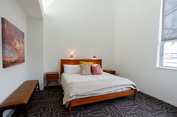 a bedroom with bed and wooden floor