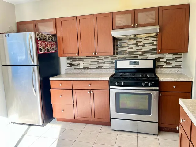 a kitchen with stainless steel appliances granite countertop a stove a refrigerator and a microwave