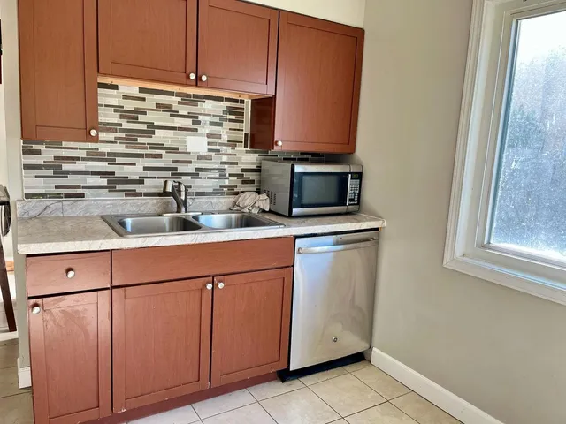 a kitchen with stainless steel appliances white cabinets and a sink