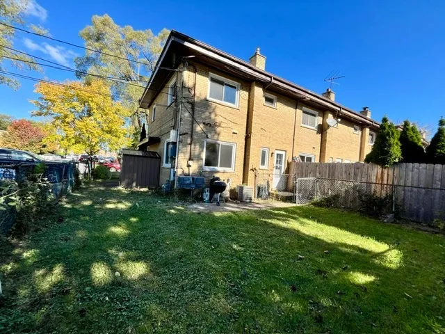 a backyard of a house with yard table and chairs