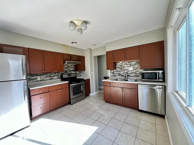 a kitchen with stainless steel appliances granite countertop a refrigerator sink and stove
