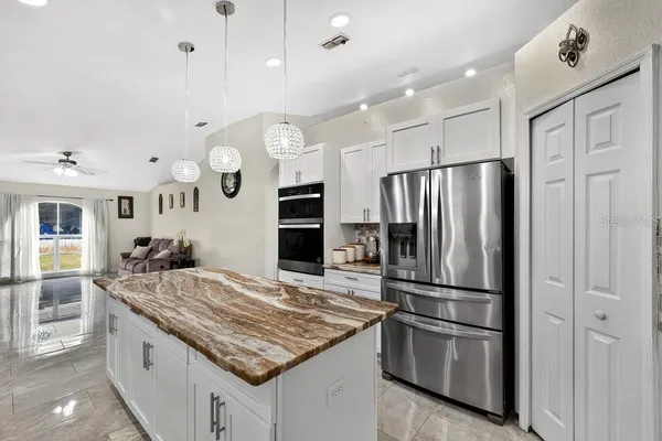 a kitchen with kitchen island a counter top space stainless steel appliances and cabinets