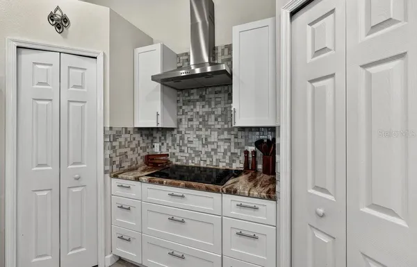 a kitchen with white cabinets and black appliances