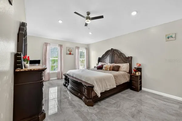 a bedroom with a bed and a ceiling fan