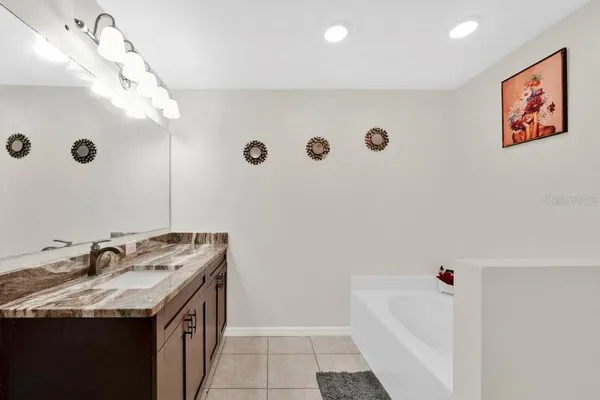 a bathroom with a sink a vanity and a tub