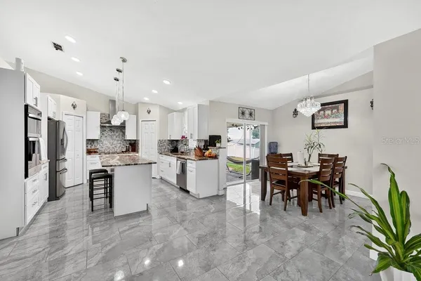 a living room with lots of furniture and kitchen view