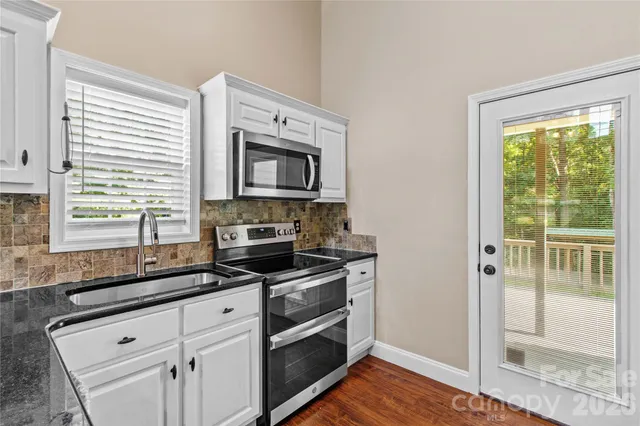 a kitchen with granite countertop a stove and a sink