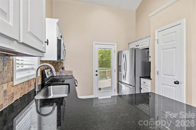 a view of a kitchen with a sink refrigerator and cabinet