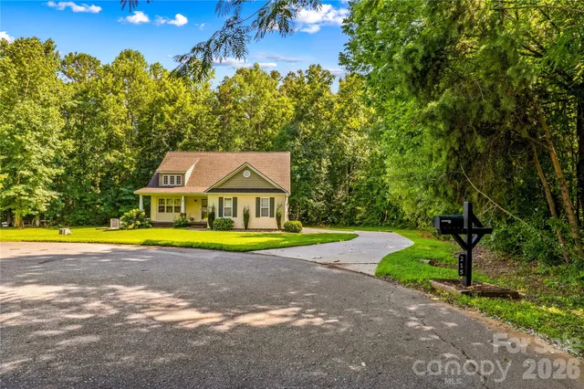 a view of a swimming pool with lawn chairs and plants