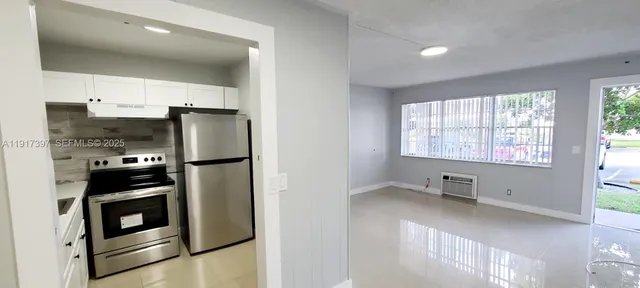 a kitchen with stainless steel appliances a refrigerator a stove a sink and a window