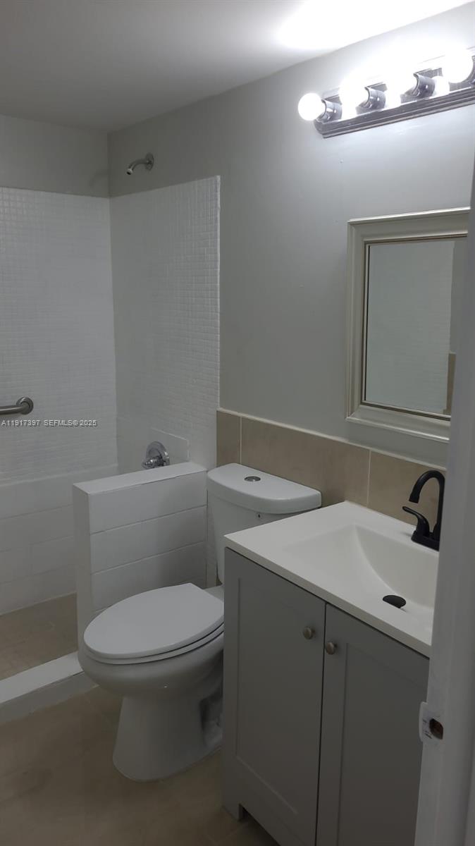 57 Cambridge C, Unit 57 West Palm Beach, FL 33417 - Photo 13 of 36 a bathroom with a sink a toilet and mirror