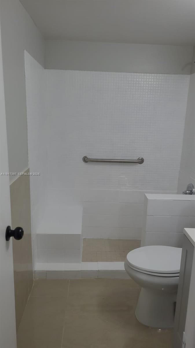 57 Cambridge C, Unit 57 West Palm Beach, FL 33417 - Photo 15 of 36 a white toilet sitting next to a bath tub