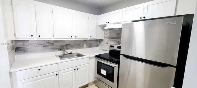 a kitchen with stainless steel appliances a refrigerator sink and cabinets