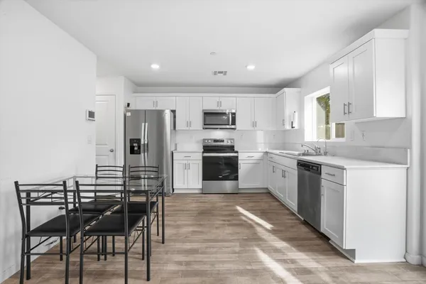 a kitchen with a sink stainless steel appliances and white cabinets