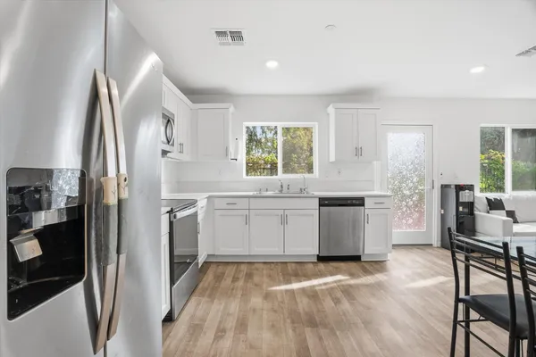 a kitchen with a sink cabinets stainless steel appliances and windows