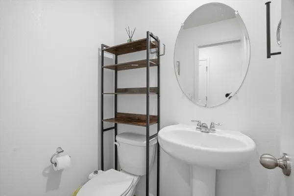 a bathroom with a sink toilet and mirror