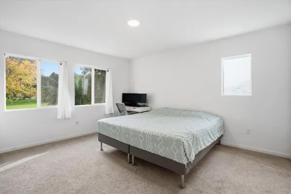 a bedroom with a bed and a large window