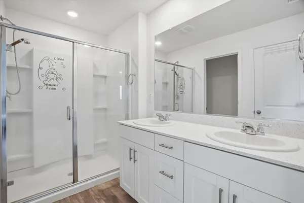 a bathroom with a shower sink and mirror