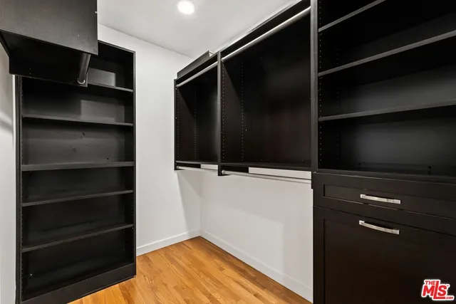 a view of walk in closet with empty racks