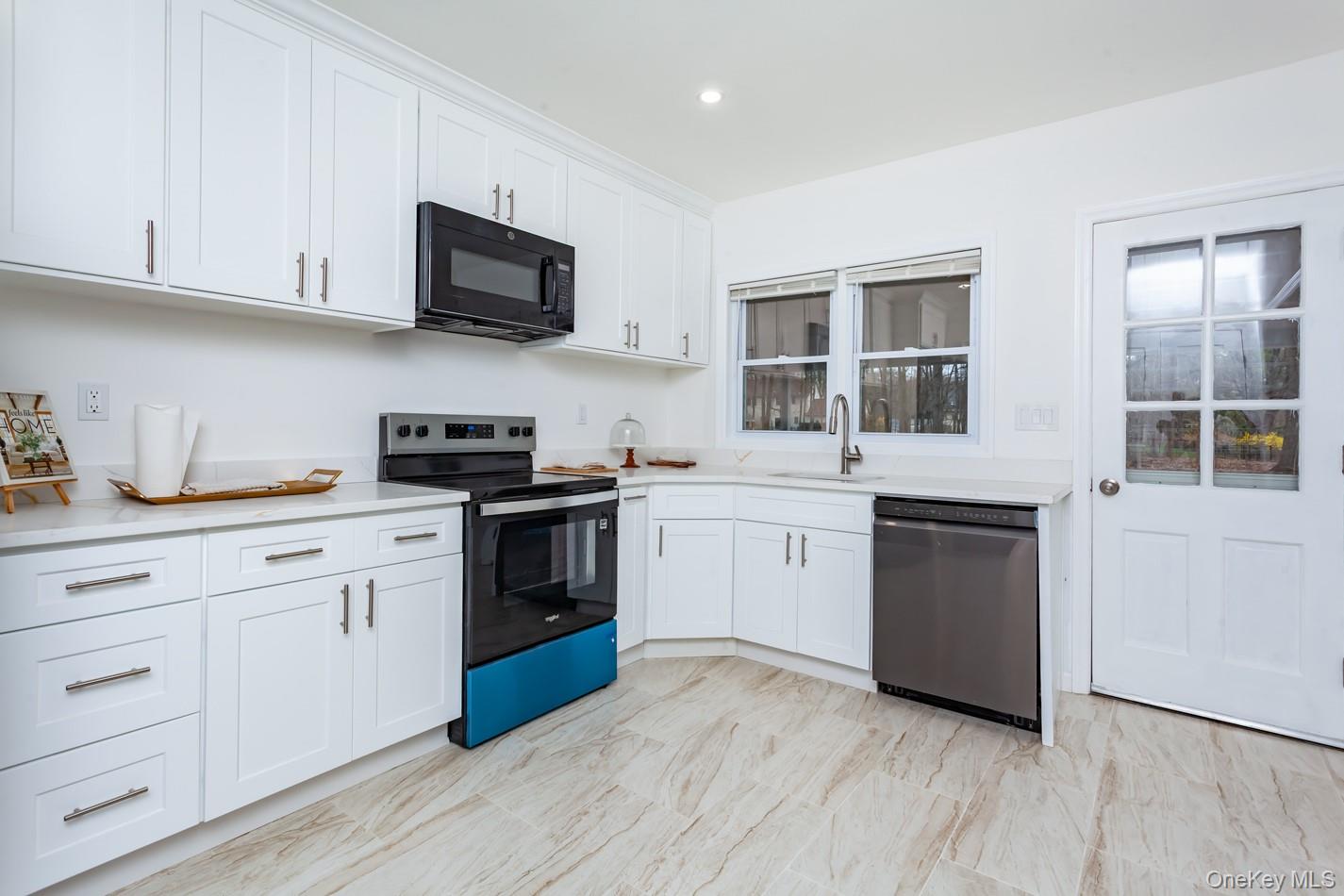 15 Waring Road Newburgh, NY 12550 - Photo 9 of 42 a kitchen with stainless steel appliances granite countertop white cabinets a sink a stove a microwave and cabinetry
