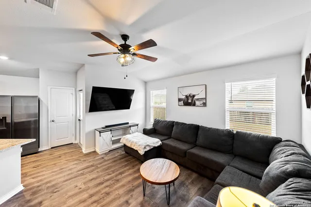 a living room with furniture a flat screen tv and a window