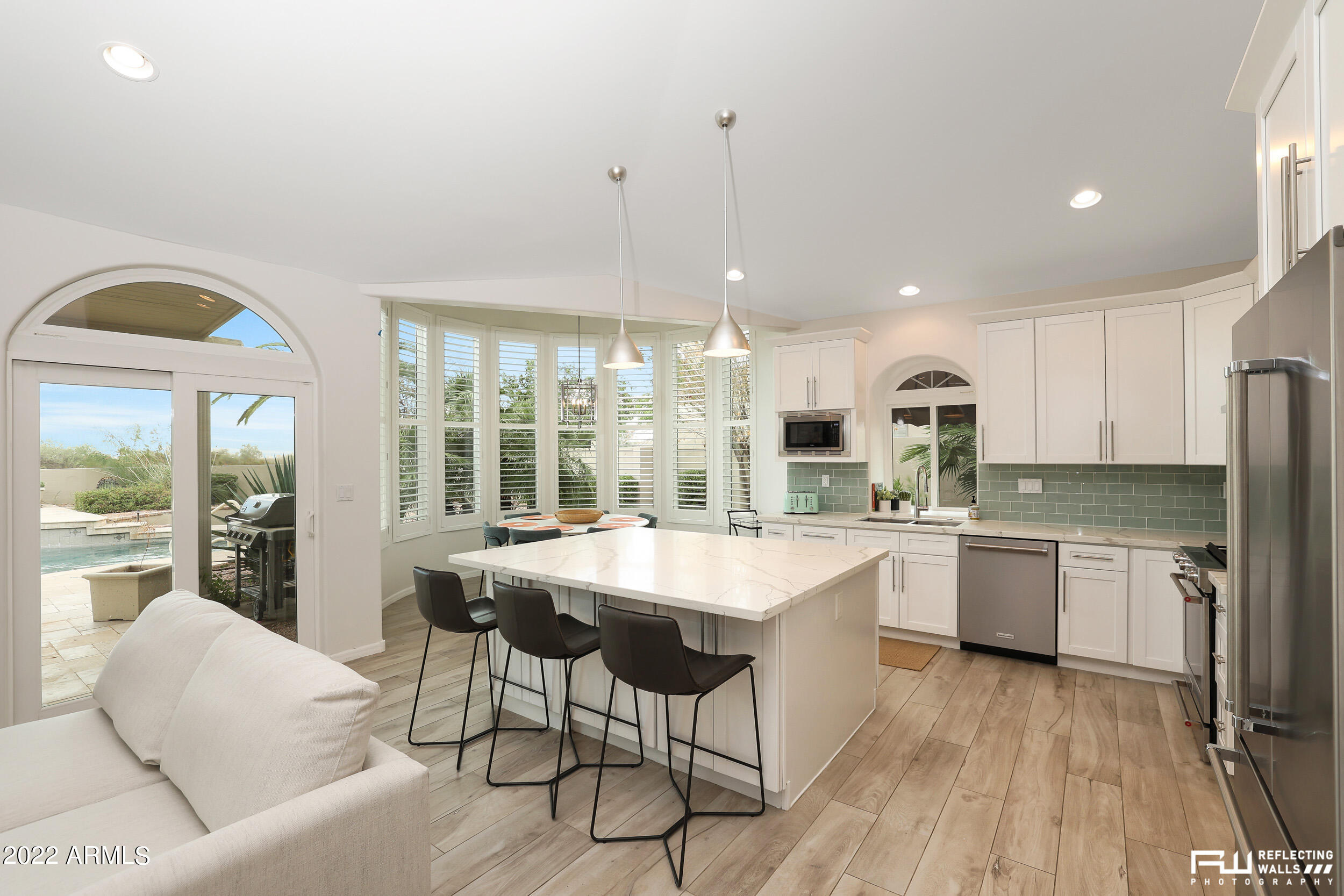 10085 East Doubletree Ranch Road Scottsdale, AZ 85258 - Photo 12 of 62 a kitchen with stainless steel appliances granite countertop a stove oven a sink dishwasher and a dining table with wooden floor