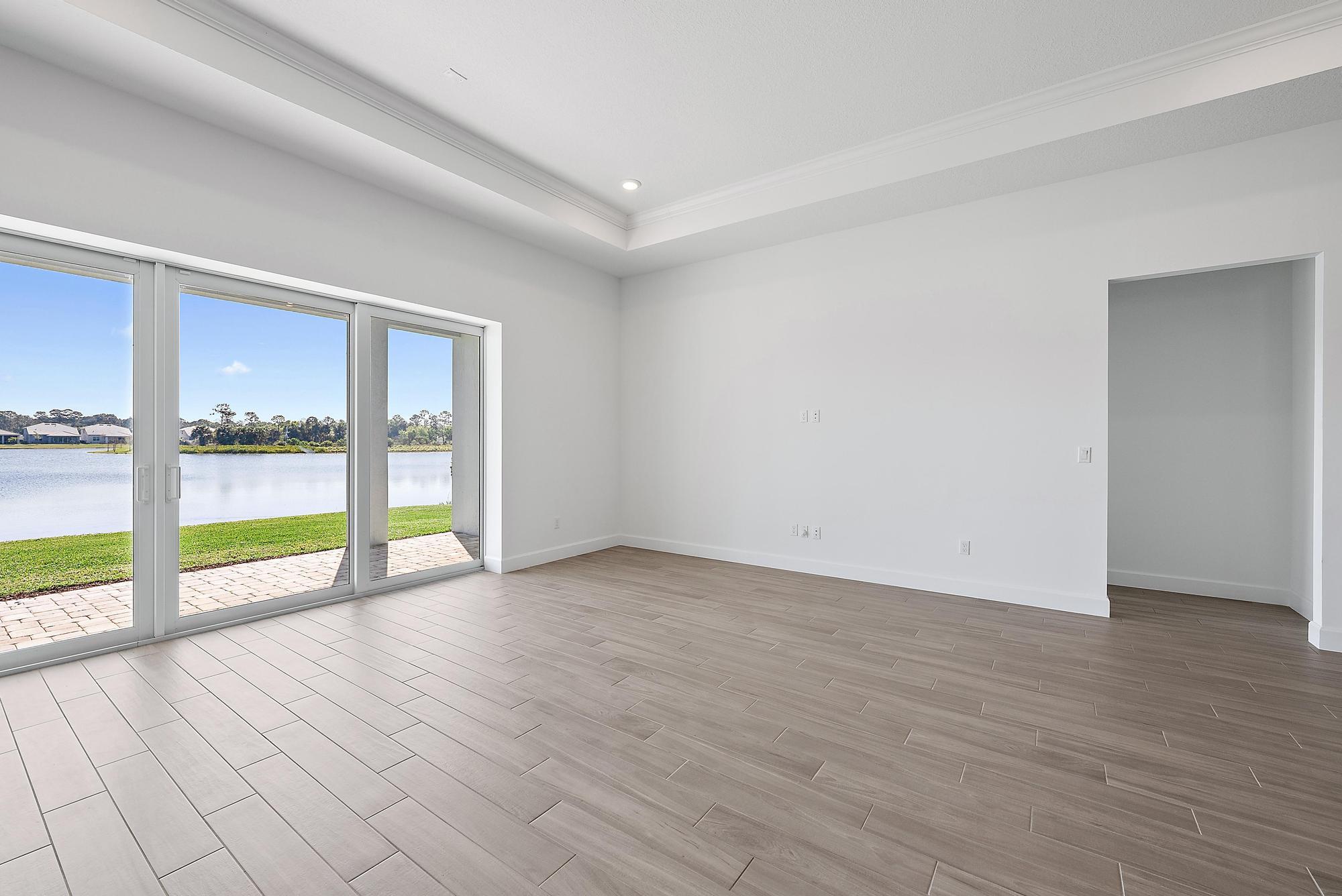 9801 Southwest Legacy Drive Stuart, FL 34997 - Photo 16 of 46 a view of an empty room with wooden floor and a window