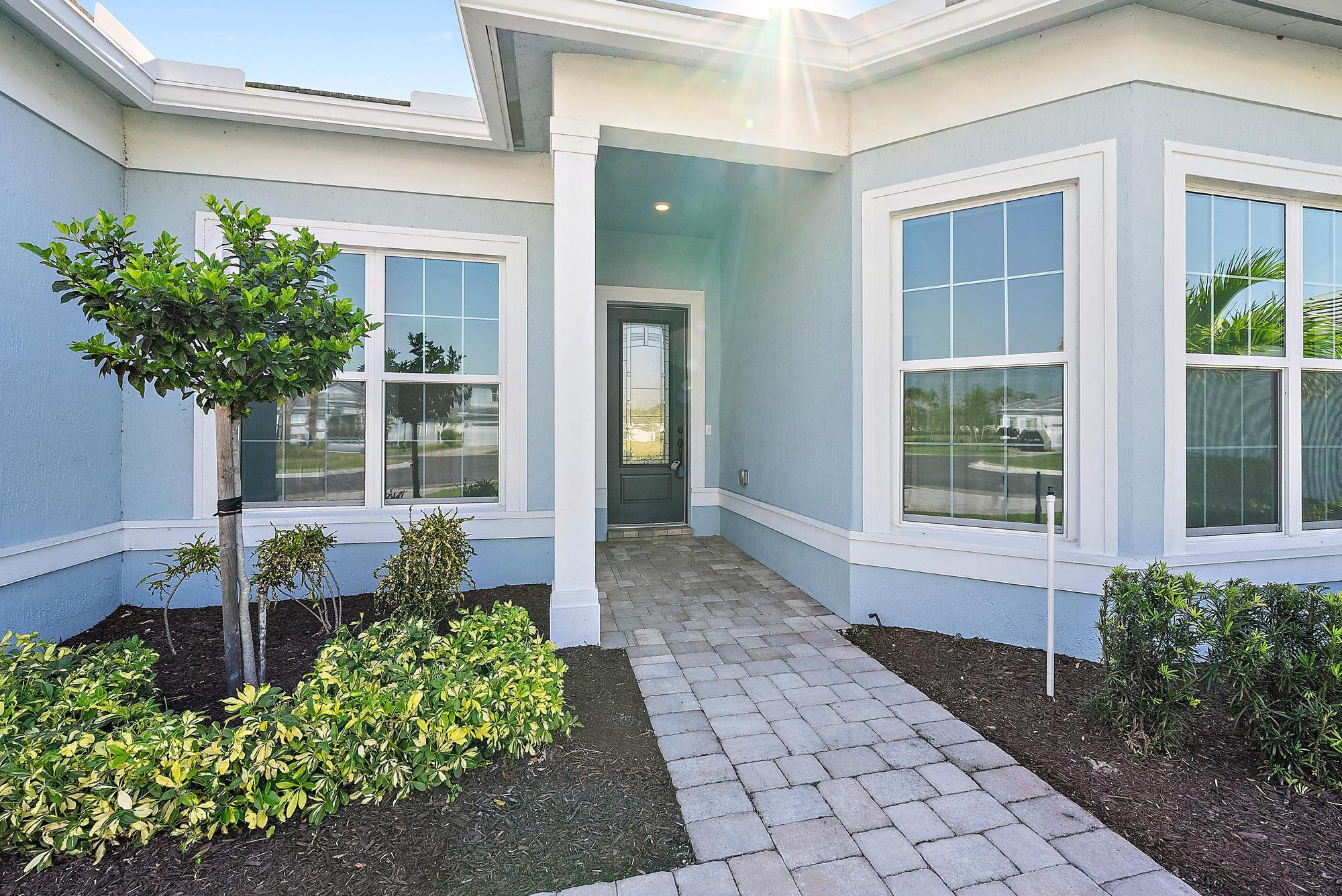 9801 Southwest Legacy Drive Stuart, FL 34997 - Photo 3 of 46 a front view of a house with garden