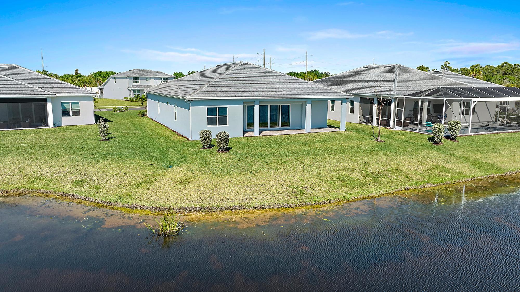 9801 Southwest Legacy Drive Stuart, FL 34997 - Photo 44 of 46 a front view of a house with a yard table and chairs