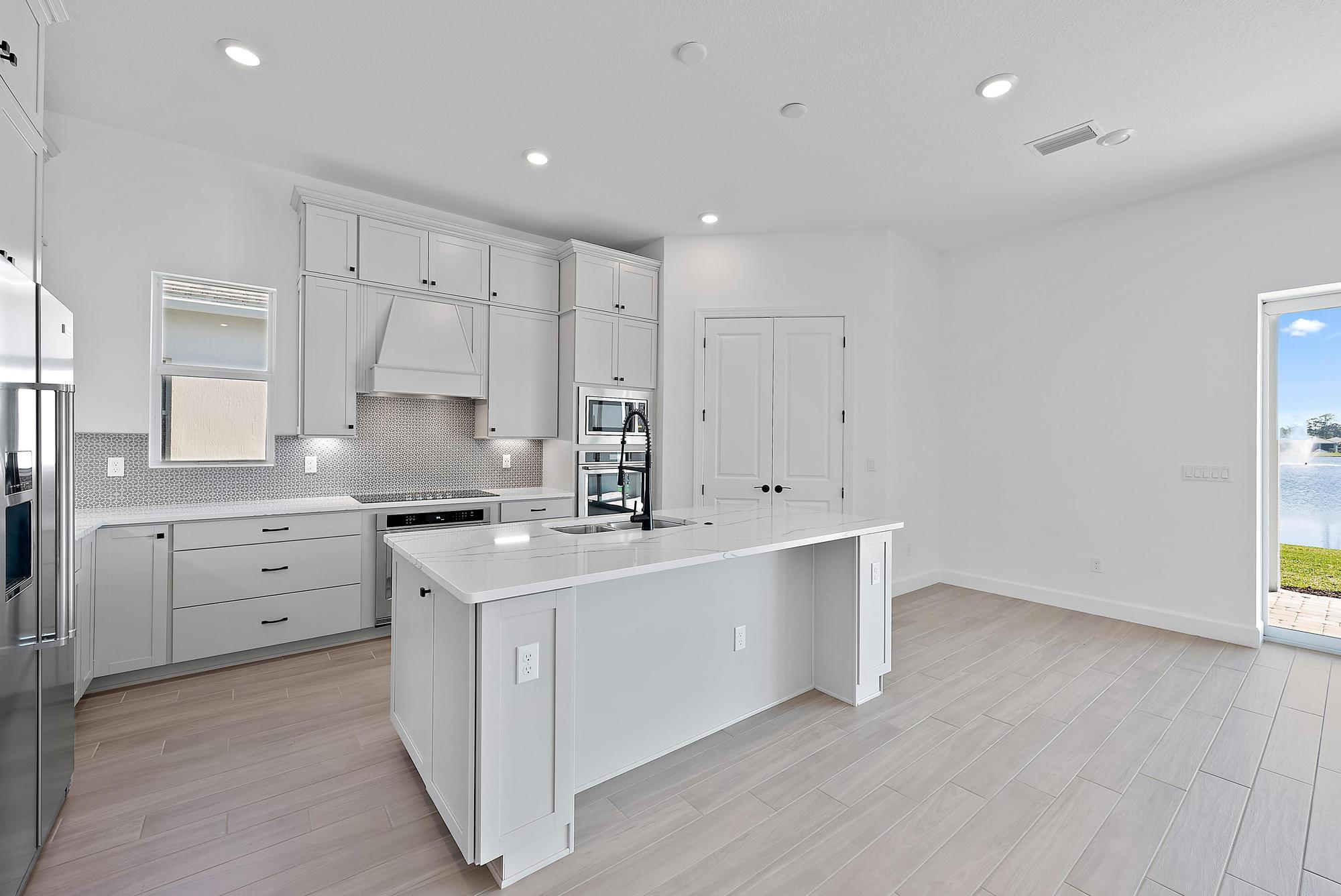 9801 Southwest Legacy Drive Stuart, FL 34997 - Photo 9 of 46 a kitchen with kitchen island a sink stove and cabinets