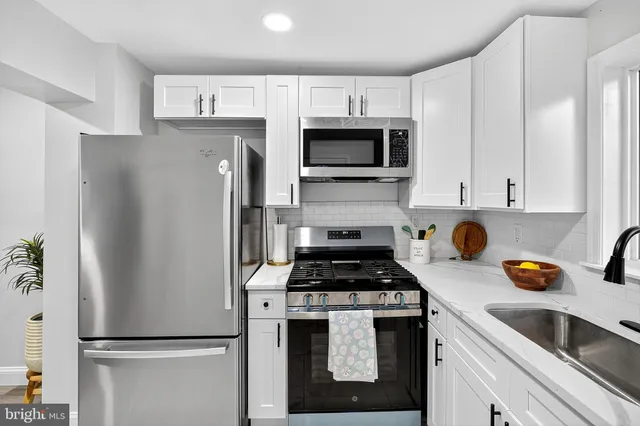 a kitchen with refrigerator a microwave a sink and cabinets