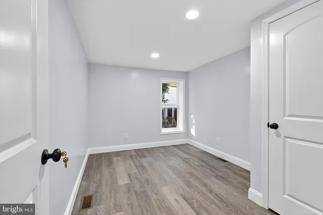 an empty room with wooden floor and a window