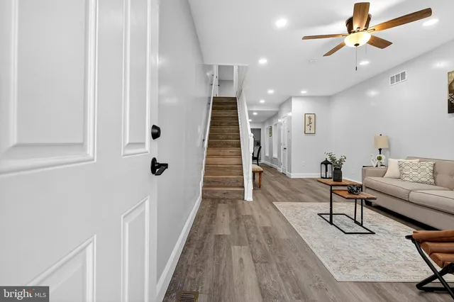 a living room with furniture and a wooden floor