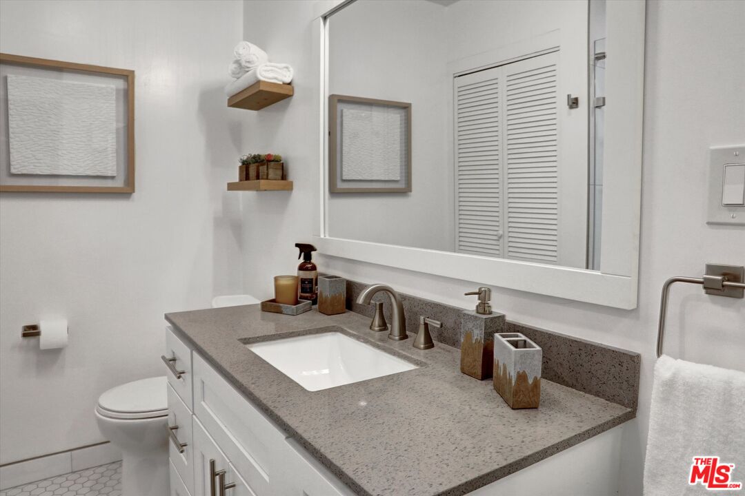 7300 Franklin Avenue, Unit 346 Los Angeles, CA 90046 - Photo 17 of 22 a bathroom with a granite countertop sink toilet and mirror