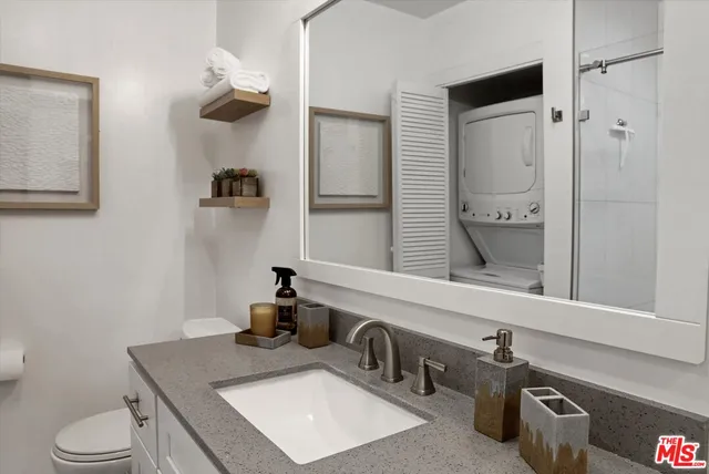 a bathroom with a sink vanity granite and toilet