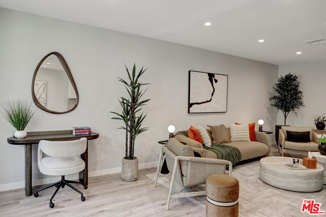 7300 Franklin Avenue, Unit 346 Los Angeles, CA 90046 - Photo 6 of 22 a living room with furniture a mirror and a potted plant