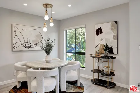 a view of a dining room with furniture a chandelier and wooden floor