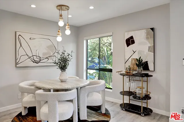 a view of a dining room with furniture a chandelier and wooden floor