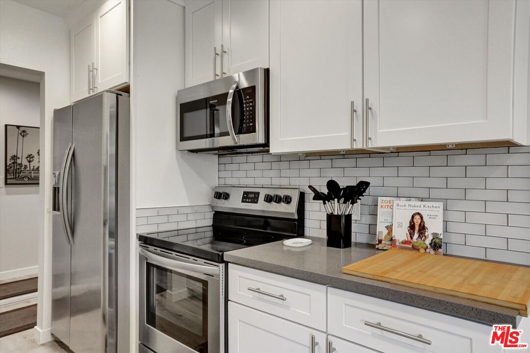 7300 Franklin Avenue, Unit 346 Los Angeles, CA 90046 - Photo 10 of 22 a kitchen with stainless steel appliances granite countertop white cabinets and a stove