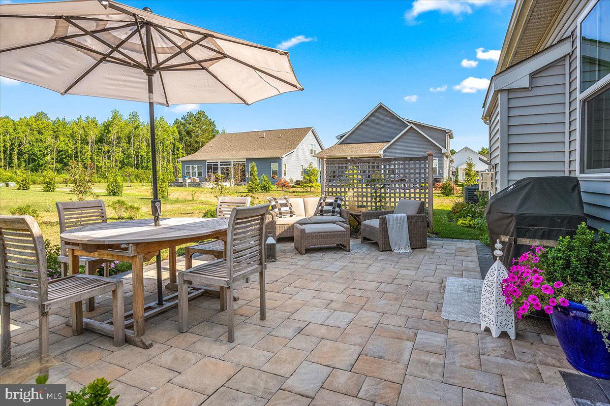 65 Old Forge Drive Ocean View, DE 19970 - Photo 44 of 69 a patio with a table and chairs under an umbrella
