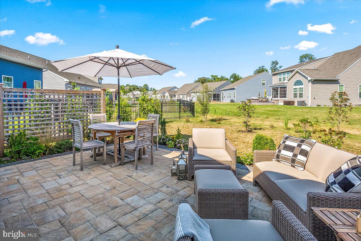 65 Old Forge Drive Ocean View, DE 19970 - Photo 46 of 69 a view of a patio with couches table and chairs under an umbrella
