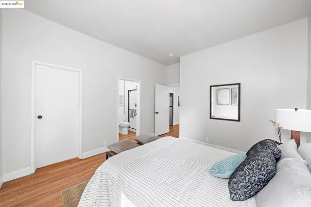 a bedroom with a bed and a lamp on dresser